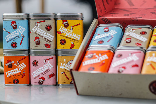 Lumberjaxe BBQ seasoning gift box containing six natural spice rub tins, including Backyard BBQ, Cowboy Butter, Hot Buffalo, Moonshine Mango, Smokehouse Beef and Louisiana Cajun seasonings